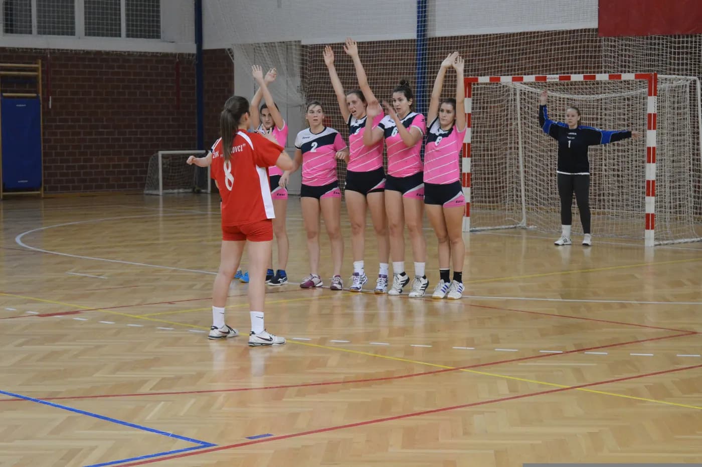 Coach talking through a drill with young handball athletes at a training camp