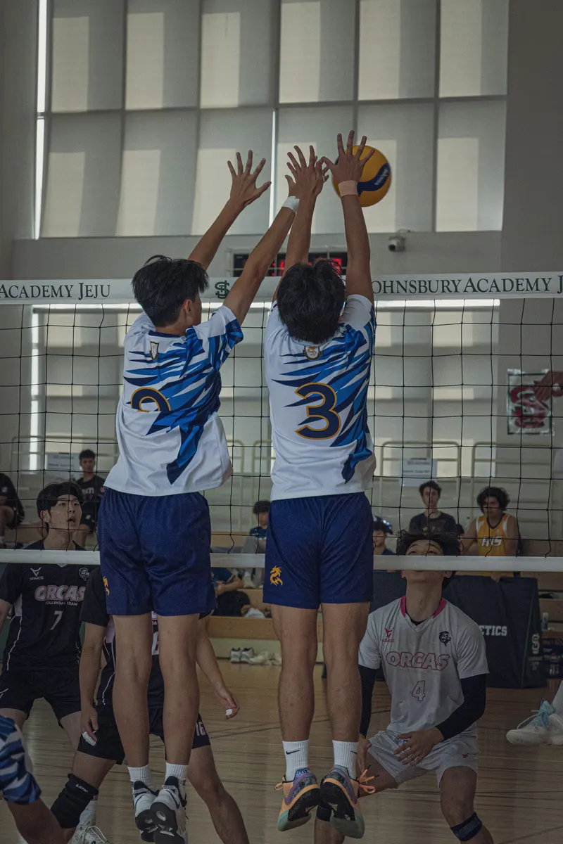 Two volleyball teams competing at the net during a game