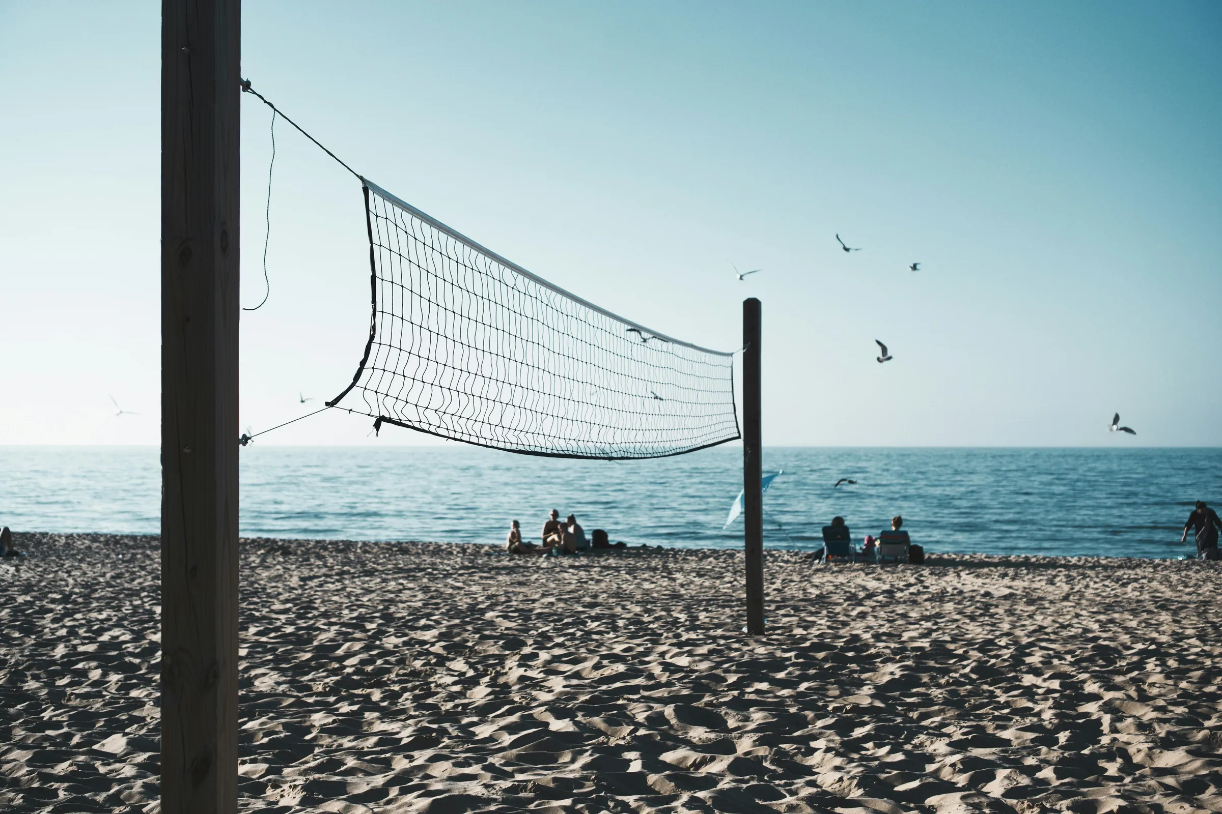 Beach volleyball players at the net during a summer tournament